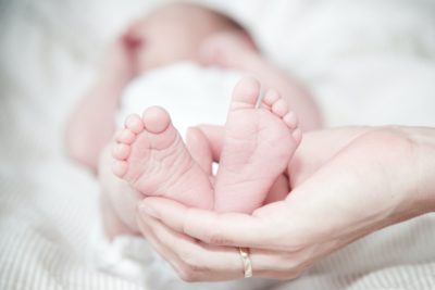 close up of hands holding baby feet 325690 - Veritas Advies