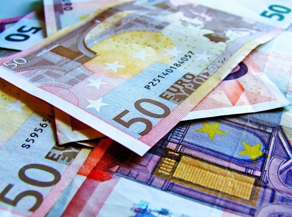 Verschillende eurobankbiljetten met een focus op vijftig eurobiljetten, die een kleurrijk ontwerp en symbolen van de Europese Unie tonen. Deze afbeelding illustreert de euro als valuta.